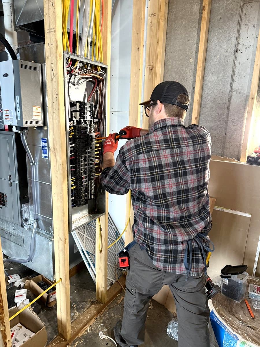 Alvis(AJ) Miller wiring an electrical panel for Seeley Lake Electric